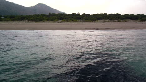 Playa-Tropical-Con-Aguas-Turquesas-Del-Océano-Que-Se-Lavan-Hacia-La-Orilla,-Salida-Aérea-Del-Carro