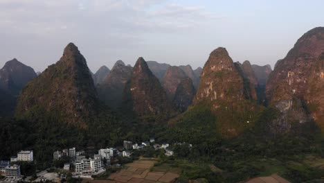Yangshuo-town-in-beautiful-karst-mountain-landscape,-sunset-aerial-view