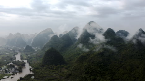 China-karst-mountains-covered-in-thick-forest,-aerial-panoramic