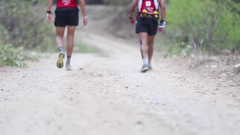 Grupo-De-Atletas-De-Maratón-Cansados-Caminando-Por-Un-Camino-De-Tierra-A-Lo-Largo-De-La-Jungla-Forestal-En-La-Hermosa-Naturaleza-Rural-De-Ecuador-50-Fps