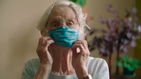 Elderly-high-risk-female-putting-on-virus-protection-face-mask
