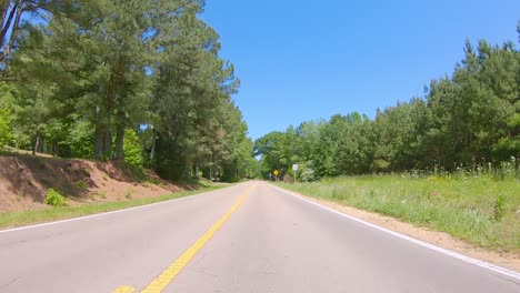 POV-driving-on-a-rural-road-through-a-wooded-area-of-rural-Alabama