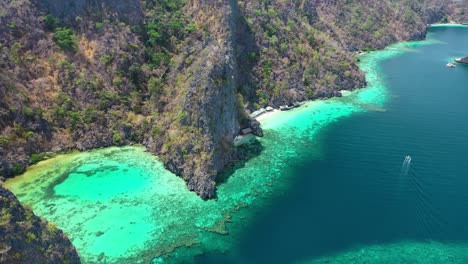 Static-Aerial-View-of-Boat-Sailing-by-Scenic-Coast-of-Coron-Tropical-Island,-Palawan,-Philippines