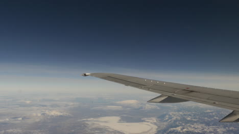 Luftaufnahme-Von-Schneebedeckten-Bergen-Aus-Dem-Fliegenden-Flugzeugfenster,-Aufgenommen-In-4k-Hoher-Auflösung