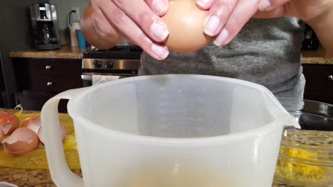 Anonyme-Weibliche-Hände-Knacken-Eier-In-Plastikkrug-Und-Bereiten-Sich-Auf-Das-Kochen-In-Der-Küche-Vor
