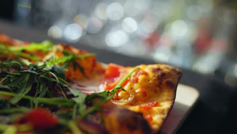 Close-up-shot-of-a-german-flat-bread-pizza-with-arugula-tomatoes-and-bread-salad-stone-oven-fresh-baked-25-fps-slowmotion