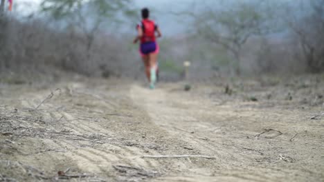 Marathon-athlete-is-running-very-fast-on-dirt-road-through-rural-nature-of-Ecuador-heading-towards-the-finish-line-trying-to-catch-up-heavy-work-out-slowmotion-25-fps
