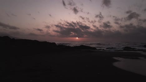 Luftbild-Absteigend-Zum-Sonnenuntergang-Silhouette-Felsiger-Küstenstrand-Meereswellen-Meereslandschaft-Horizont