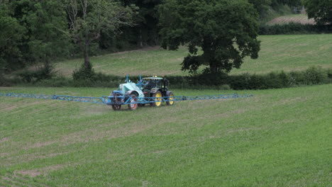 Ein-Traktor,-Der-Sprühgeräte-Abschleppt,-Sprüht-Ein-Feld-Mit-Neu-Gepflanztem-Labyrinth-In-Einem-Feld-In-Warwickshire,-Großbritannien