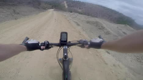 Mountainbike-cyclist-goes-very-fast-down-the-mountain-on-a-sand-dirt-road-and-loses-control-and-crashes-and-falls-down-in-the-desert-of-Ecuador-go-pro-helmet-shot