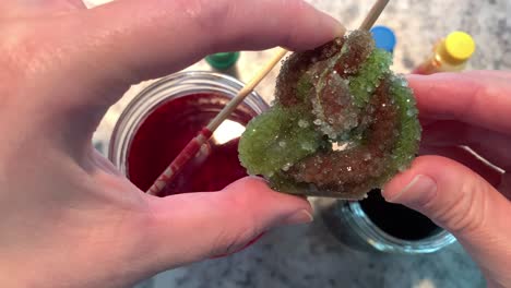 A-hand-holding-a-sparkly-Borax-crystal-with-green-and-purple-colors