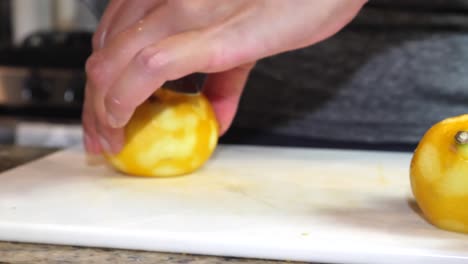 Slow-motion-anonymous-female-hands-slicing-lemon-citrus-fruits-closeup