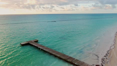 AERIAL-Sunrise-Over-Tropical-Ocean-Views-And-Wooden-Pier