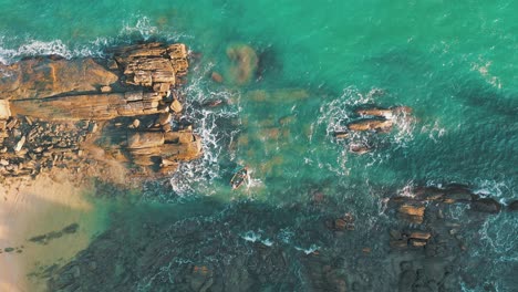 fisher-rowing-boat-drone-aerial-top-down-view-paradise-rocky-shore