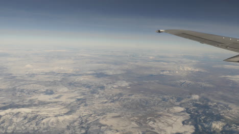 Luftaufnahme-Von-Schneebedeckten-Bergen-Aus-Dem-Fliegenden-Flugzeugfenster,-Aufgenommen-In-4k-Hoher-Auflösung