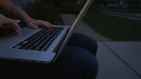 Nahaufnahme-Einer-Erwachsenen-Kaukasischen-Frau,-Die-An-Einem-Sommerabend-Draußen-Auf-Der-Einfahrt-Einen-Latptop-Computer-Benutzt