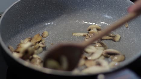 Sauteing-Sliced-Mushrooms-In-A-Skillet-With-Small-Amount-Of-Cooking-Oil---close-up