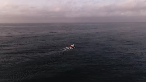 Luftbild,-Das-In-Richtung-Fischerboot-Auf-Ruhigen-Meereswellen-Fliegt,-Bewölkter-Sonnenuntergang,-Meereslandschaft