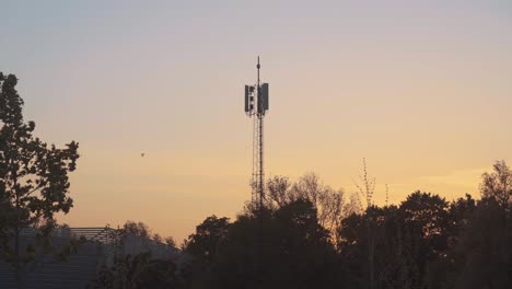 Telekommunikationsturm,-Der-Bei-Einem-Sonnenuntergang-Gegen-Einen-Dramatischen-Himmel-Steht---Mittelbreite-Aufnahme