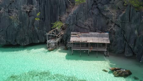 Aerial-View-of-Lonely-Female-in-Hut-on-Exotic-Hidden-Banul-Beach,-Coron-Island,-Philippines