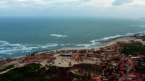Wide-aerial-drone-shot-of-the-small-hidden-beach-town-of-Sibauma-near-Pipa-in-Northern-Brazil-with-tropical-beaches-and-sandy-roads