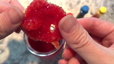 A-hand-holding-a-sparkly-red-Borax-crystal