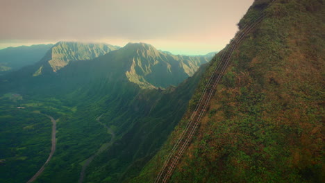 Hombre-Subiendo-Escaleras-Al-Cielo,-Vuelo-Aéreo-Sobre-Un-Paisaje-épico,-Hawaii