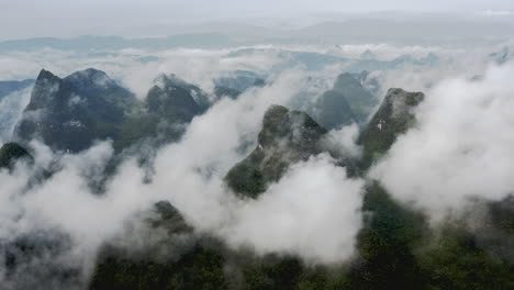 Picos-De-Montaña-Kársticos-De-China-Cubiertos-De-Nubes,-Paisaje-Del-Río-Yulong,-Vista-Aérea