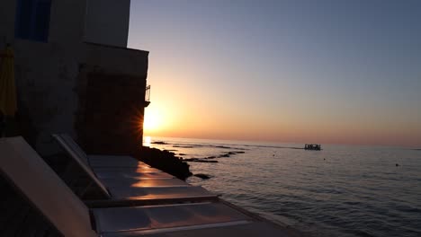 Malerischer-Strandblick-Auf-Ruhiges-Ozeanwasser-Und-Boot-Bei-Sonnenuntergang,-Reifen,-Libanon,-Pfanne-Rechts-Offenbaren