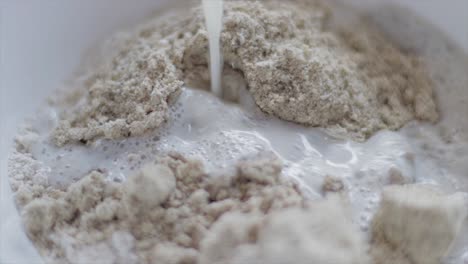 Adding-milk-in-an-oatmeal-biscuits-blended-mixture