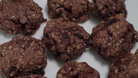 Rotating-chocolate-oatmeal-raisin-cookies-on-white-background,-closeup-detail