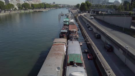 Overhead-drone-shot-of-boats-docked-along-the-shore-of-the-Seine-River-in-Paris