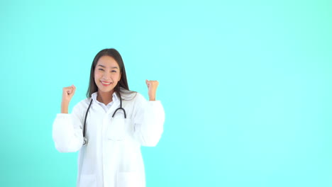 Fröhliche,-Glückliche-Asiatische-Ärztin-Vor-Blaugrünem-Hintergrund