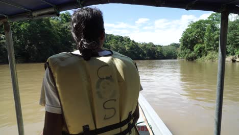 Männlicher-Reiseleiter,-Der-In-Einem-Traditionellen-Tourenboot-Sitzt,-Das-Schnell-über-Einen-Breiten-Fluss-In-Ecuador-Segelt