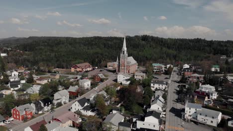 Fliegen-über-Das-Dorf-Le-Bic-Mit-Der-Kirche-Sainte-cecile-Du-Bic-Im-Hintergrund-In-Bas-Saint-Laurent-In-Rimouski,-Quebec,-Kanada
