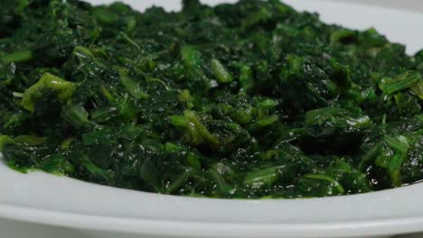 Cooked-Green-Spinach-in-White-Bowl,-Closeup-Tilt-Down-Shot