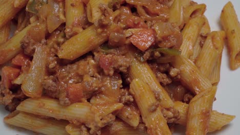 Rotating-Pasta-Bolognese-with-Penne-Noodles,-Overhead-Closeup