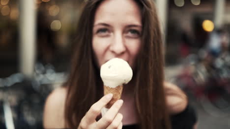 Closeup-portrait-of-a-young-beautiful-smiling-woman-enjoying-Italian-ice-cream,-slow-motion