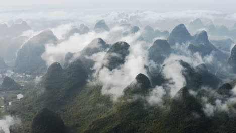 Chinese-karst-mountain-landscape-in-clouds,-aerial-panoramic