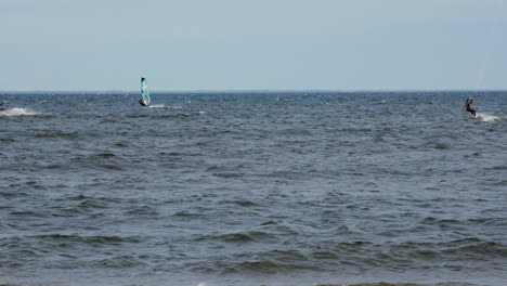 Kiteboarder,-Die-An-Einem-Sonnigen-Tag-Auf-Dem-Tiefblauen-Meer-Surfen---Mittlere-Aufnahme