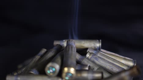 A-pile-of-smoking-bullet-shells-on-the-ground-in-slow-motion