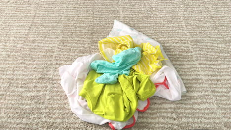 Schmutzige-Babykleidung-Auf-Einen-Haufen-Auf-Dem-Boden-Werfen