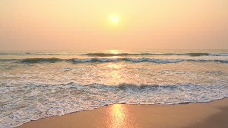 Zeitlupenszene-Eines-Romantischen-Sonnenuntergangs-über-Dem-Friedlichen-Ozean-Mit-Wellen,-Die-Nassen-Sand-Erreichen