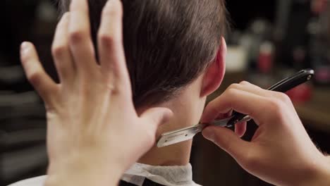 close-up-of-a-barber-shaving-his-neck-with-a-dangerous-razor