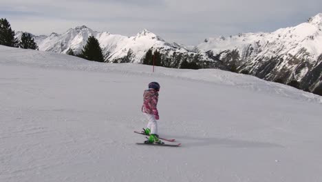 Young-child-is-skiing-down-a-ski-slope-with-save-ski-technique