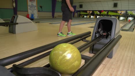 Man-Casually-Walks-Up-And-Throws-Orange-Ball-In-Retro-Bowling-Alley,-Knocks-Down-One-Pin