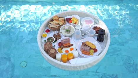 Top-view-on-lunch-food-tray-floating-on-the-pool-water