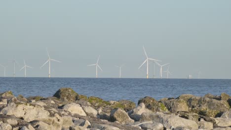 Alternative-energy-offshore-windmill-utility-turbines-spinning-on-marine-seascape-horizon