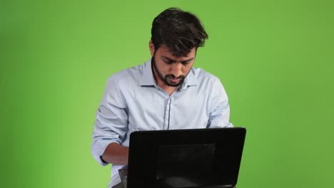 Portrait-of-young-attractive-bearded-man-architect-working-at-a-desk,-use-laptop-in-the-office-green-screen