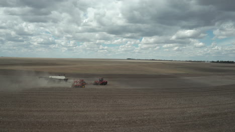Farmer-With-Tractor-Seeding-Crops-At-The-Vast-Field-In-Saskatchewan,-Canada